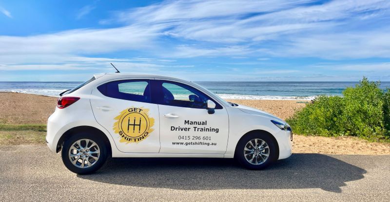 Get Shifting Instructor car, white Mazda 2